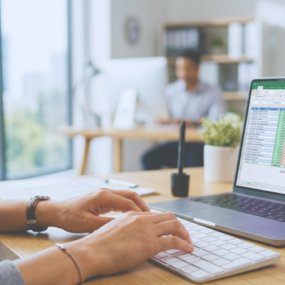 Profissional de escritório analisando relatórios financeiros criados com as fórmulas de Excel mais usadas na rotina administrativa.